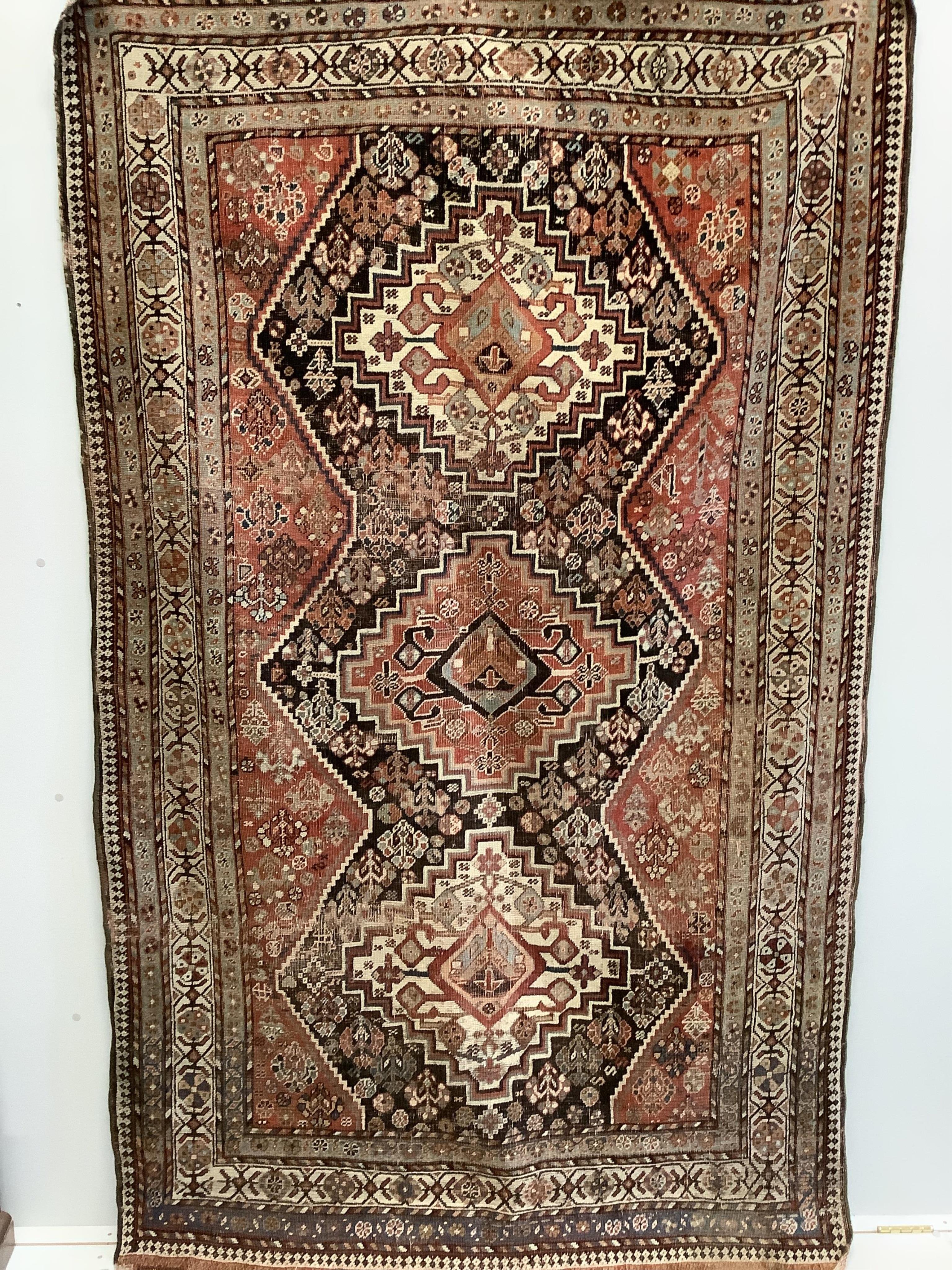 An antique Shiraz triple medallion rug, 230 x 142cm. Condition - poor